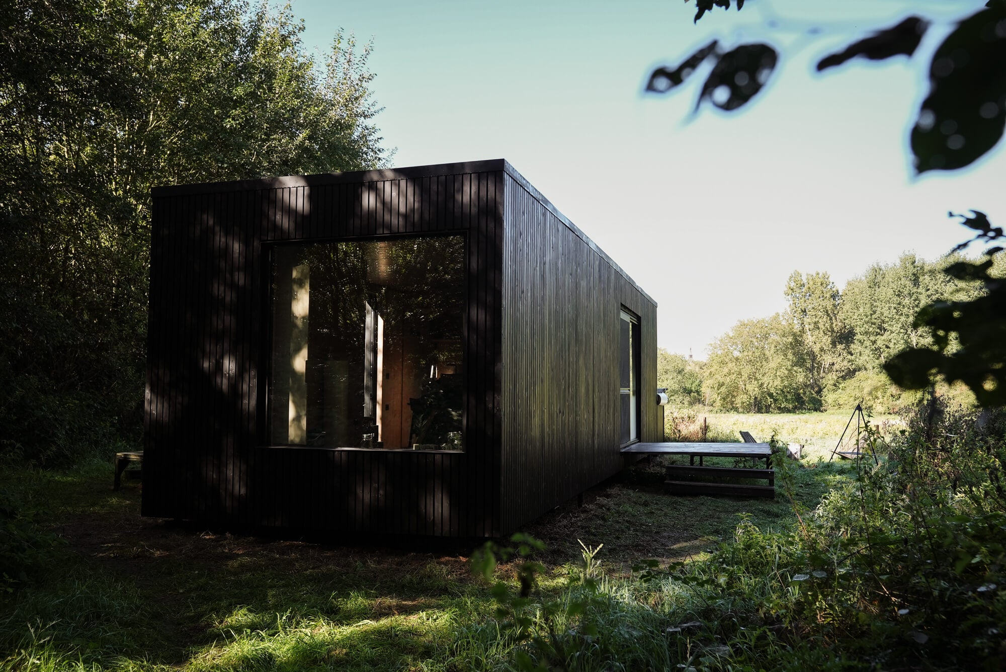 A black cabin outfitted with vertical wood siding finished using Rubio Monocoat's DuroGrit exterior wood finish.
