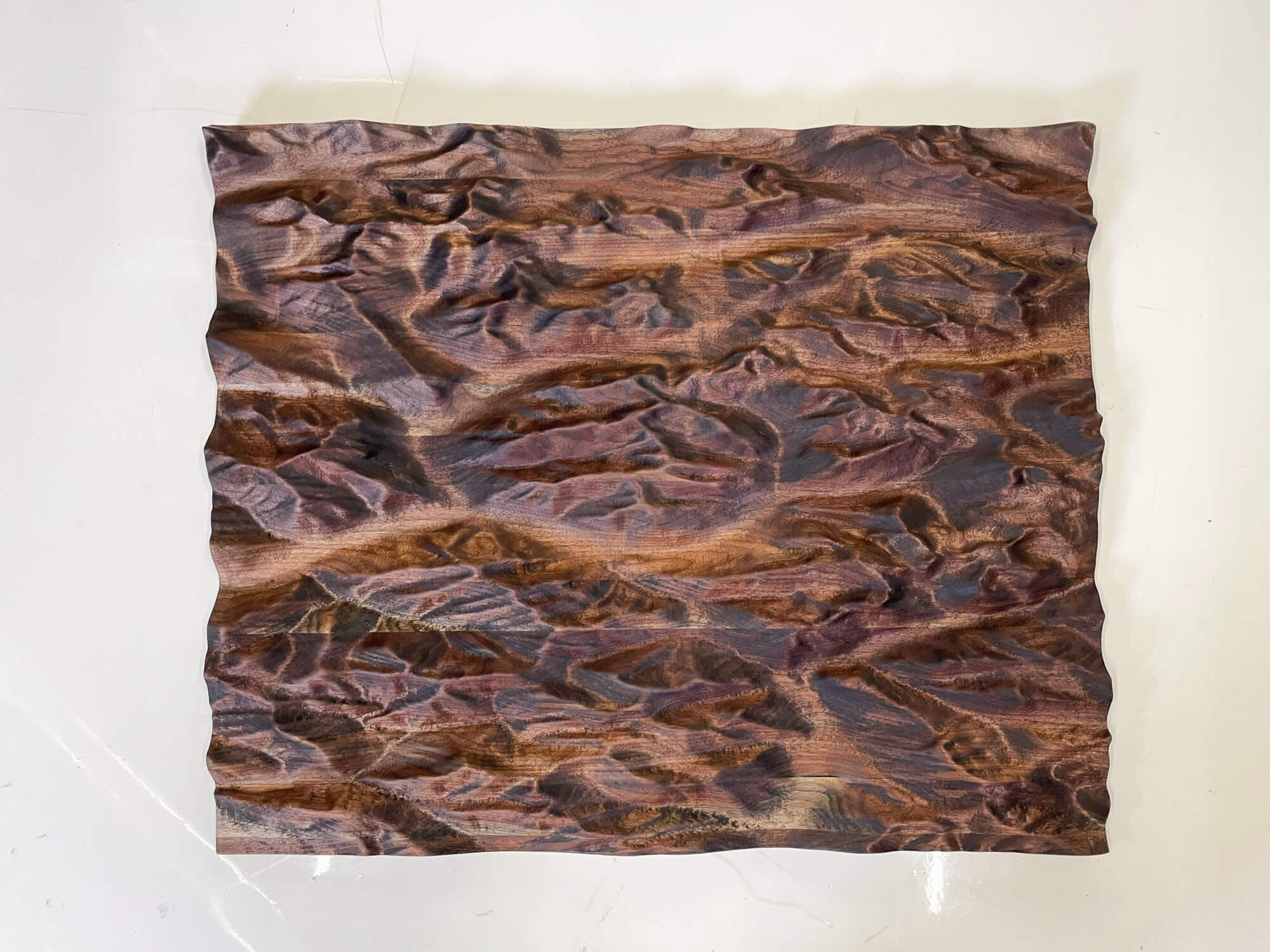 A piece of wall decor that is a topographic map of the Canadian Rocky Mountains finished with a natural hardwax oil.