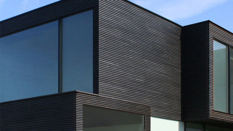 A modern home with dark exterior wood siding.