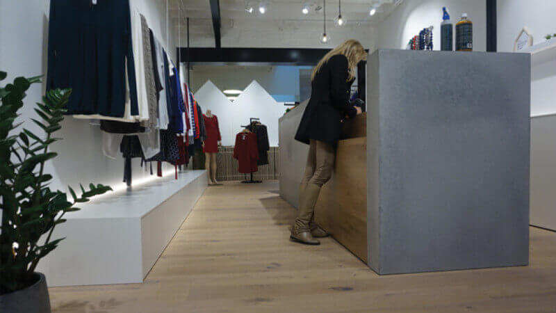 Front desk at a clothing store with wooden floors finished with Rubio Monocoat.