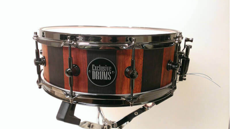 A custom stave wood drum shell made out of padouk and wenge with a matte wood finish.