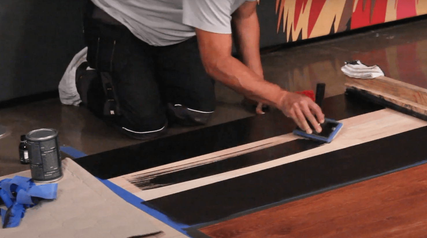 A man applying Rubio Monocoat Precolor Easy on a demo panel