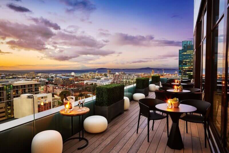 A beautiful hotel wood balcony overlooking the city during sunset.