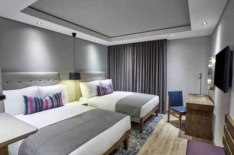 A hotel room with matte finish wood furniture.