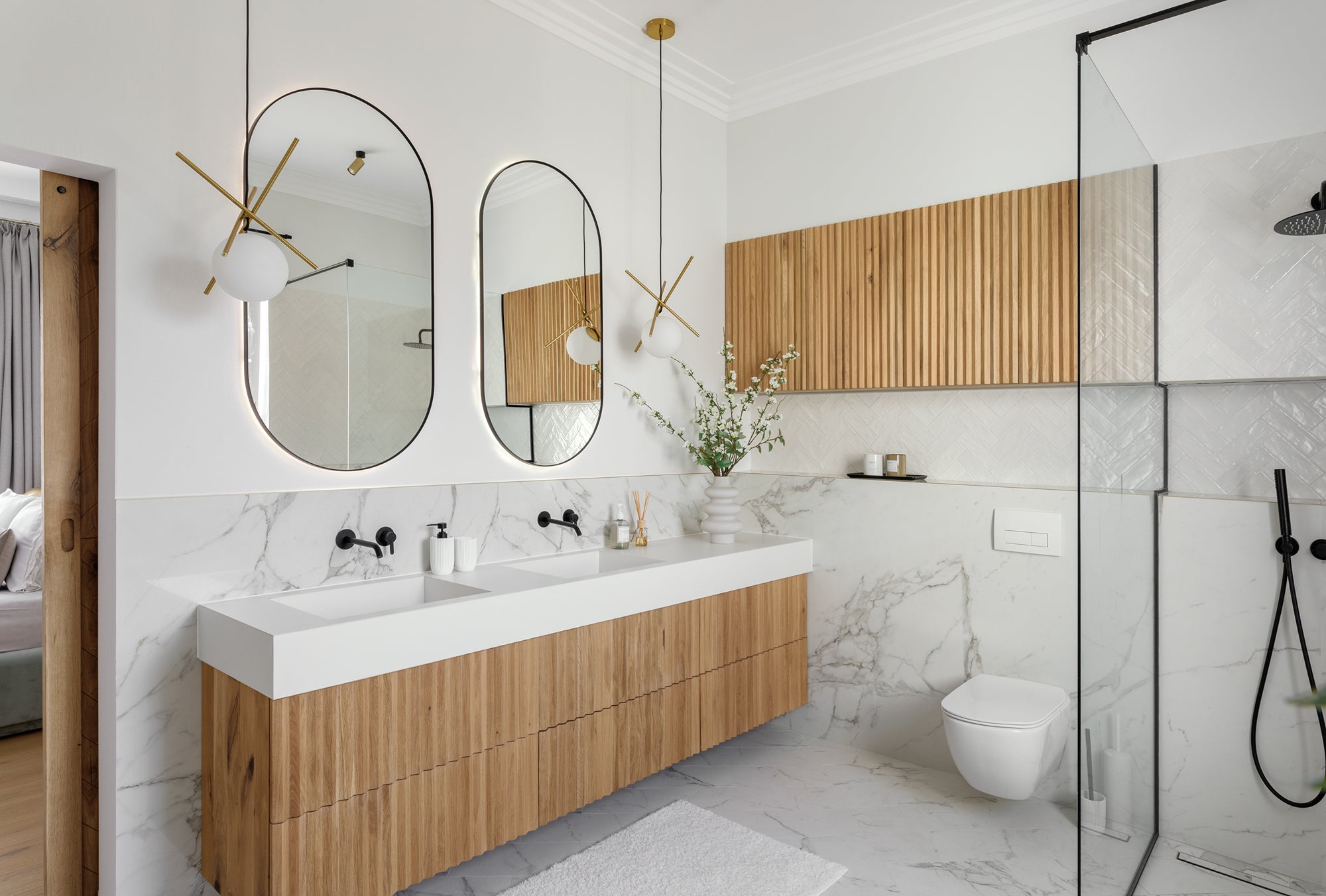 Modern bathroom with a thick stone countertop, white oak slatted vanity and slatted wall feature finished with a hardwax oil finish.