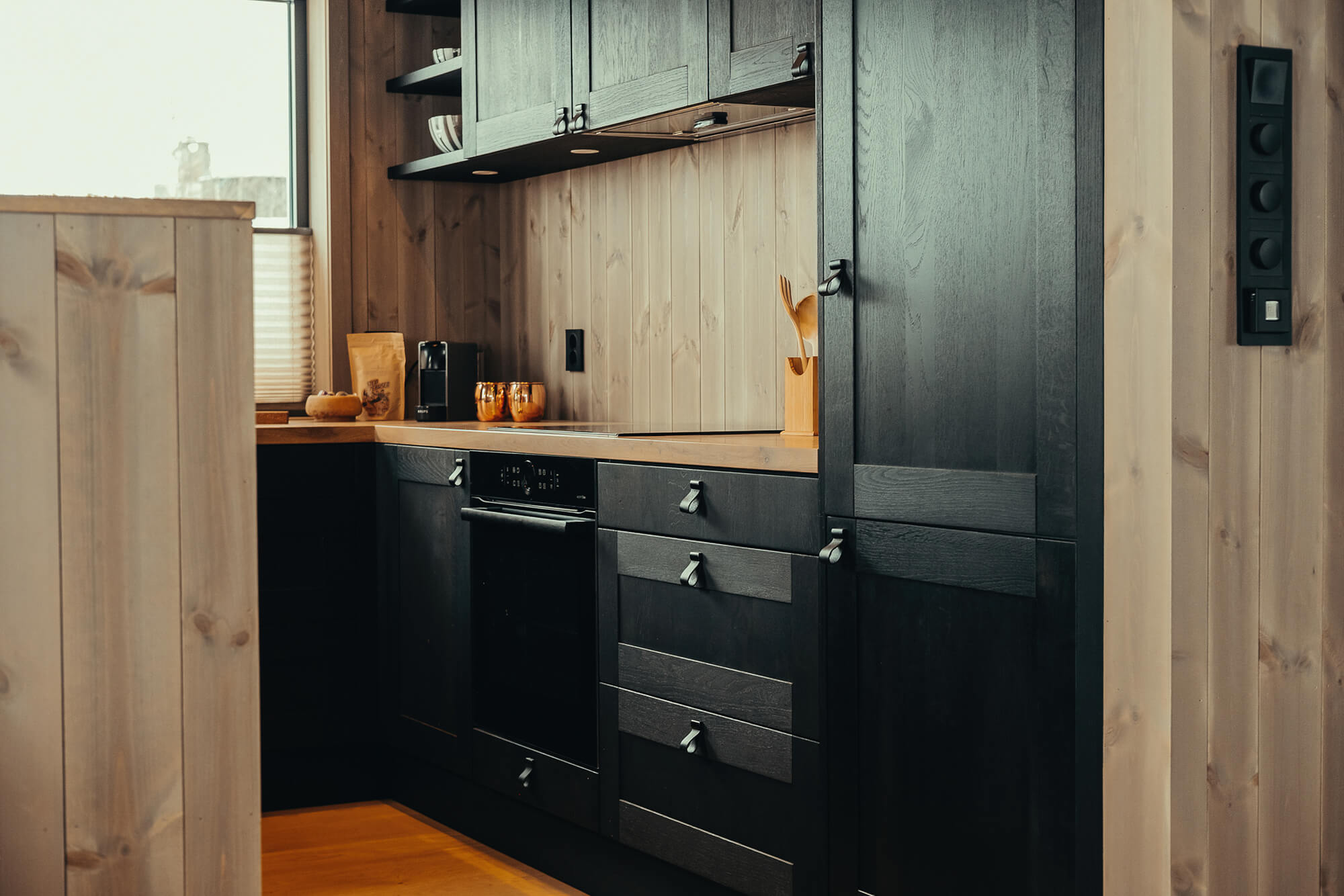 Black kitchen cabinets treated with Rubio Monocoat stain and hardwax oil products in a Scandinavian kitchen.