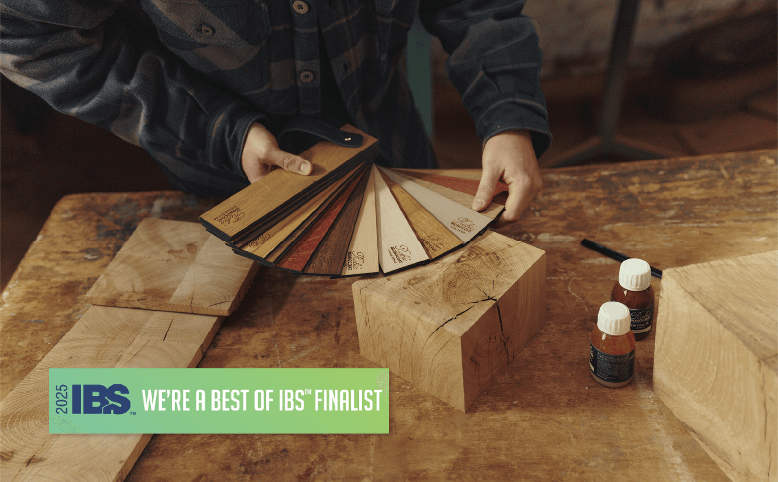 A man holding a wood fan deck finished with Oil Plus 2C hardwax oil wood finish for interior wood projects. Also pictured is a Best of IBS Finalist medallion.
