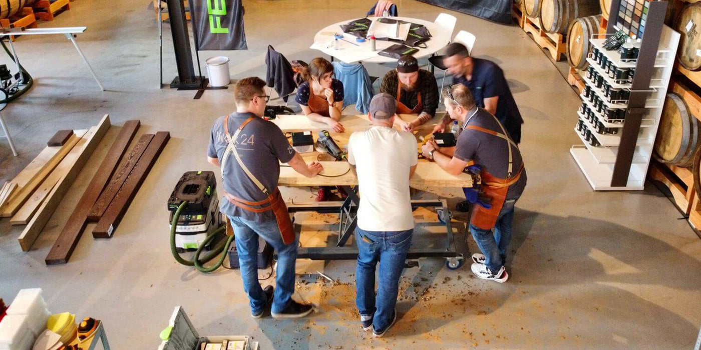 Woodworkers gather around a table an discuss their build at the Rubio Monocoat Atelier