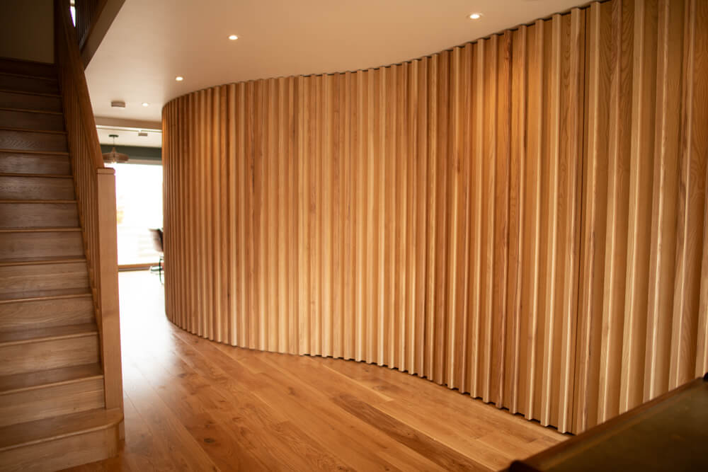 Curved wall with millwork made from ash wood finished with Rubio Monocoat Oil Plus 2C hardwax oil.