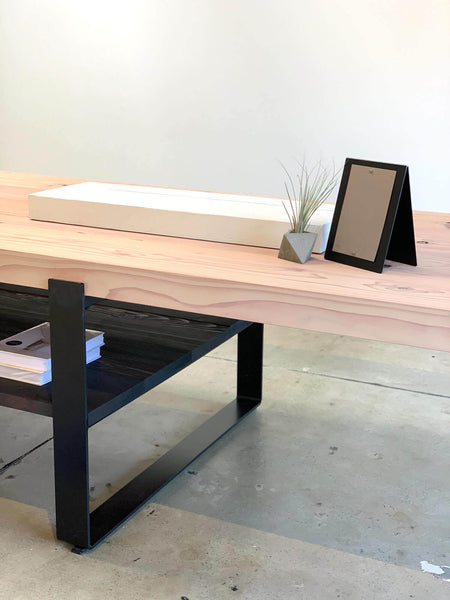 A redwood display table in a retail store with various objects on it.