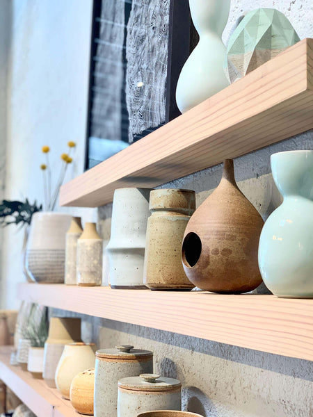 A detail shot of floating shelves made of redwood in a retail store.