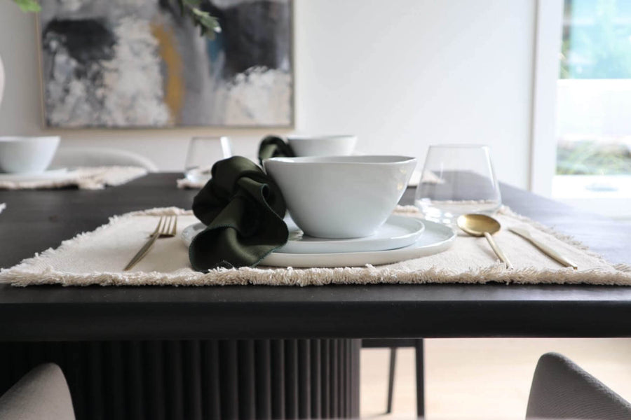 One of the place settings sitting on top of the black fluted white oak dining table crafted by Dove Design Co.