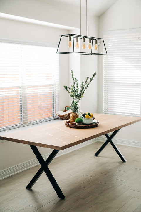 A modern table with metal "X" legs made from white okay and finished with Rubio Monocoat Oil Plus 2C "White 5%".
