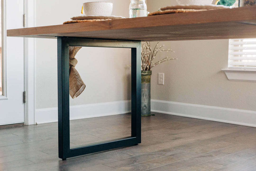 Rectangular steel legs on a modern coastal dining table.