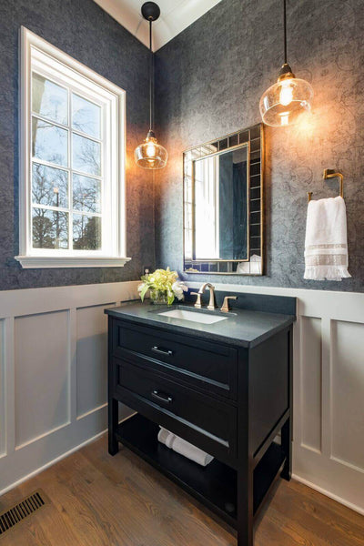 Beautifully designed guest bathroom with hardwood flooring and a dark vanity.
