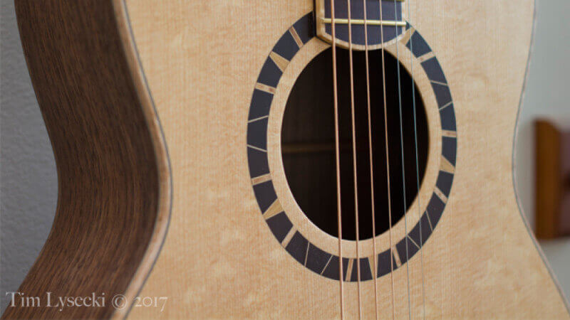 The soundhole in a birdseye maple acoustic guitar with Oil Plus 2C wood finish.