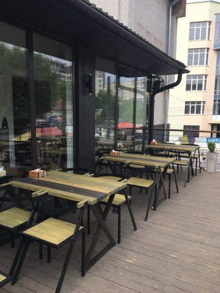A restaurant patio with a wood deck and tables on it.