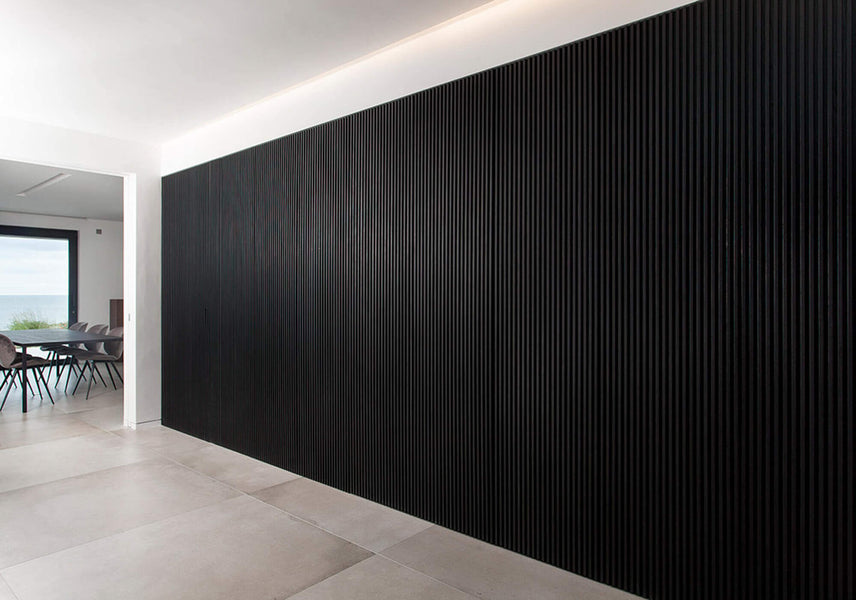 An off angle shot of the black slatted wall finished with Rubio Monocoat products.