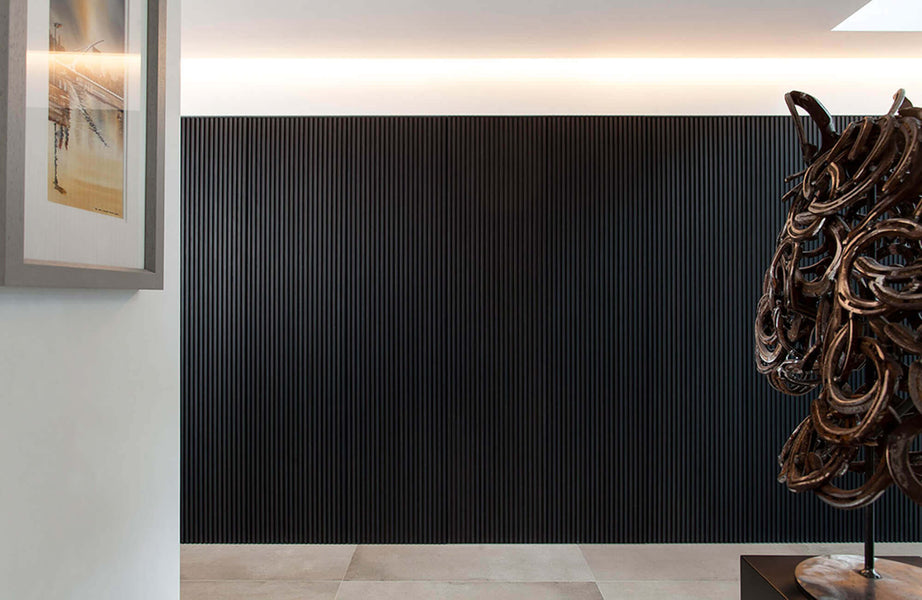An interesting view of the black slatted wall with a horseshoe statue in the foreground.