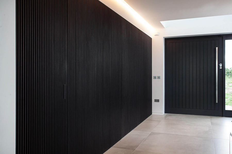 Another similar view looking toward the entrance of the home that features a black slatted wall finished with Rubio Monocoat finishing products.