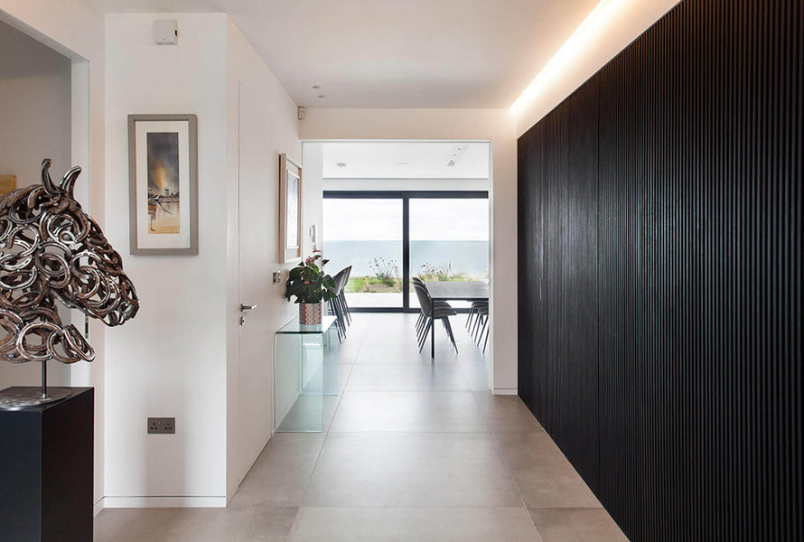A view of the black slatted wall to the right looking out to windows.