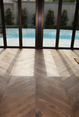 Sun shines on wood herringbone floor finished with Rubio Monocoat's hardwax oil.