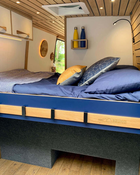 Conversion van bed with plenty of storage both underneath and overhead.