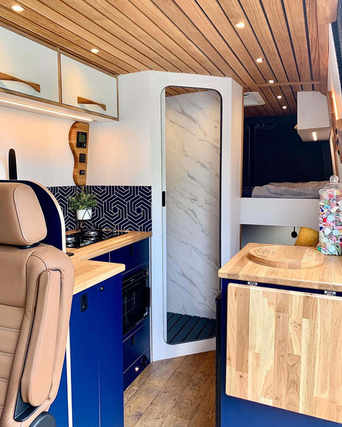 View from the passenger seat of a conversion camper van. The kitchen and bathroom area are seen here.