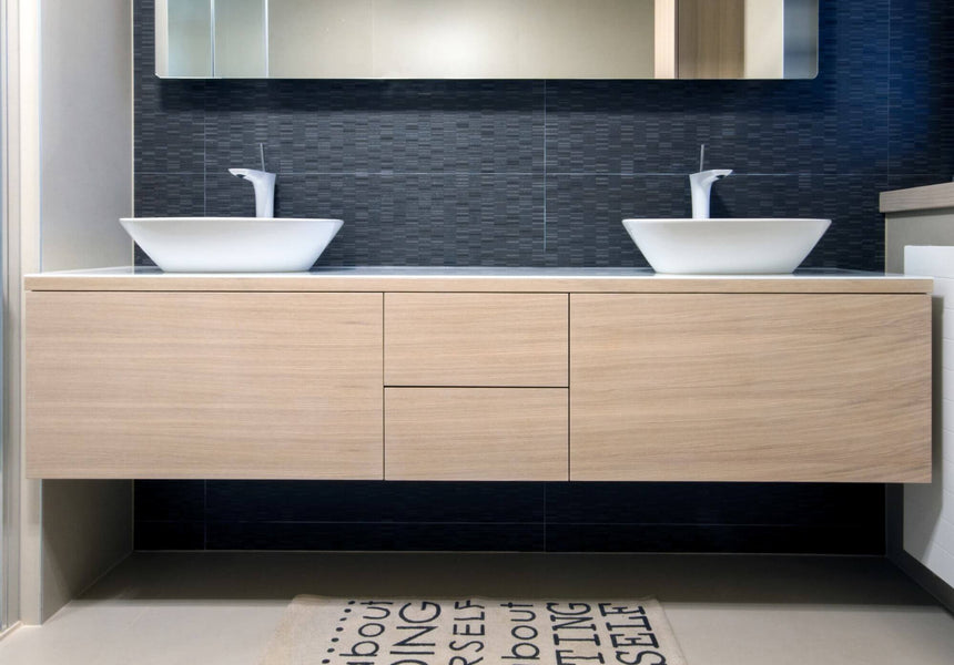 Bathroom vanity with light wood drawer fronts.