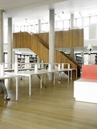 A room in a college with tables on a french oak hardwood floor