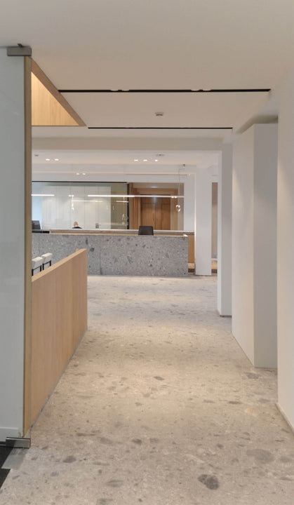 Office building with concrete flooring and wood cubicles.
