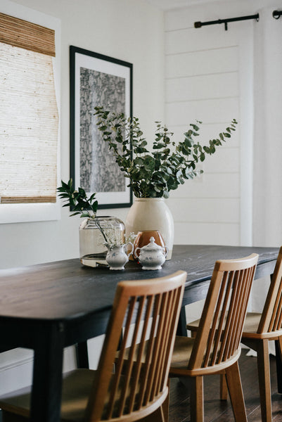 Three wood-toned chairs sit in the foreground. A black stained ash table finished with Rubio Monocoat products is the main focal point.