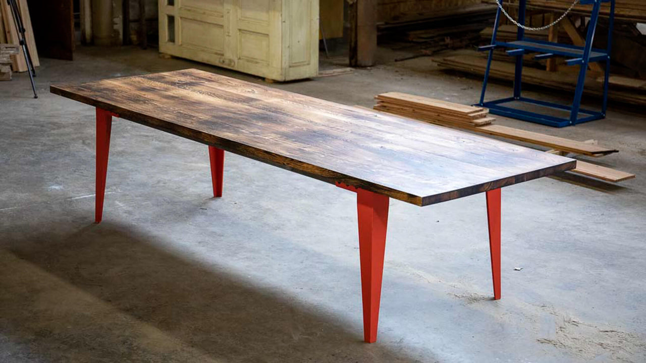 Orange metal legs are on a charred white oak dining table finished with Rubio Monocoat Oil Plus 2C hardwax oil wood stain and finish.