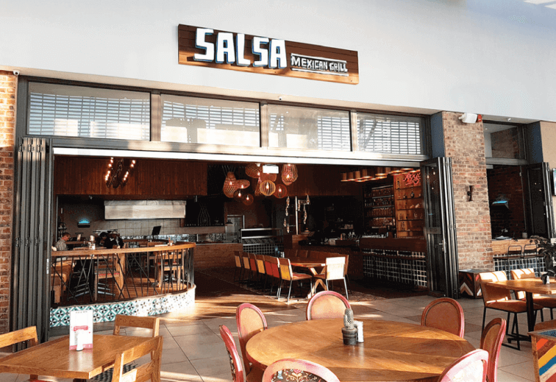 The storefront of Salsa, a mexican restaurant with matte finish wood details throughout.