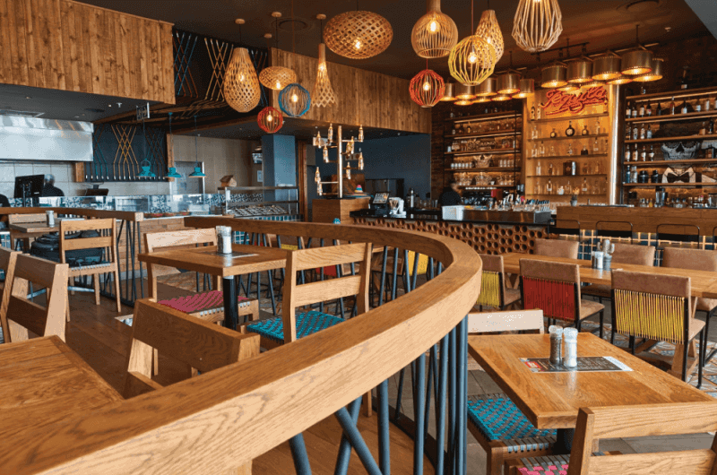 The interior of a mexican food restaurant style with natural colored wood throughout.