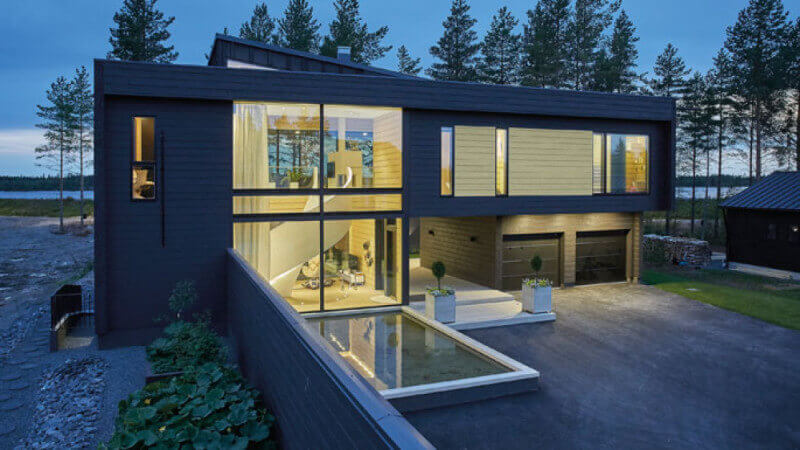 A modern architecture home with a pool in the backyard and wood paneling on the outside of the home.
