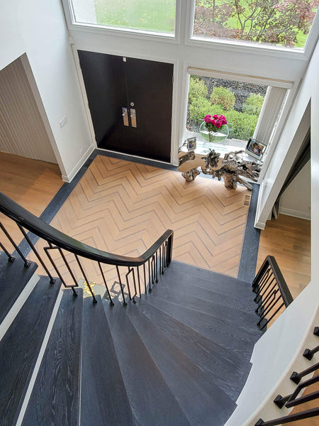 Curved hardwood stair case leading to an entry foyer, with solid hardwood flooring and treads, finished with Rubio Monocoat products.