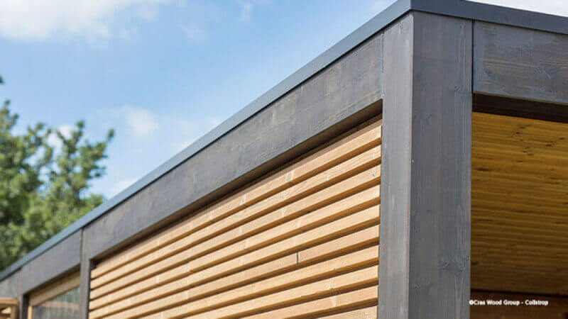 A carport finished with a dark exterior wood finish.