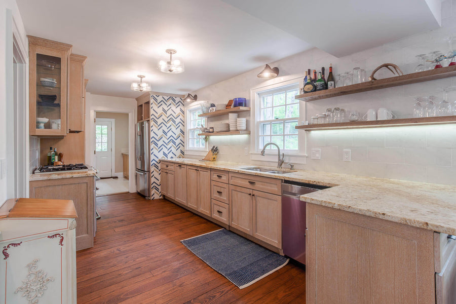 Kitchen with light rift sawn white oak cabinets, floating shelves, and a white walls.