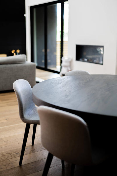 An off angle showing the detail of the modern black round dining table.