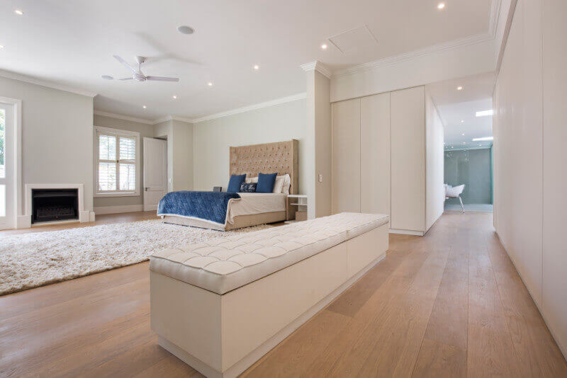 Natural colored wide plank wood flooring in master bedroom.