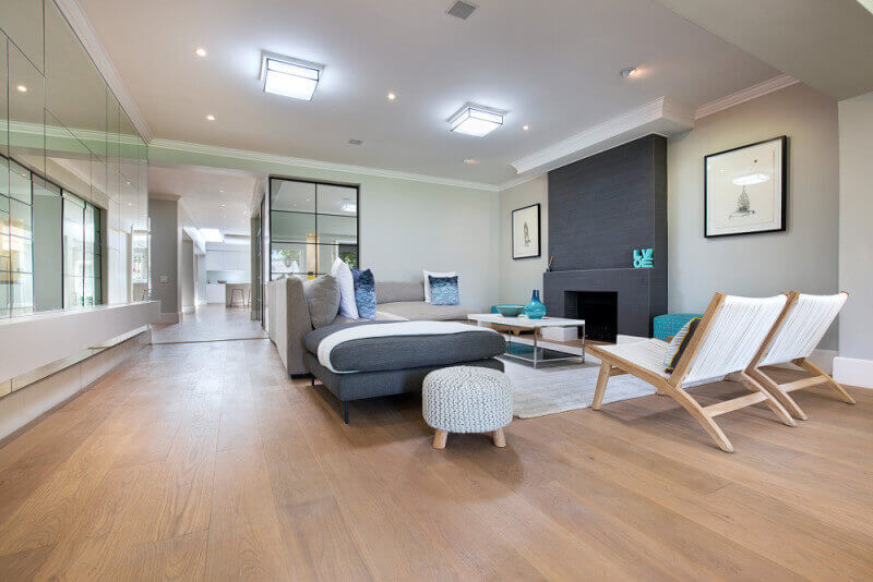 Luxury wide plank floors in a living room finished with natural floor finish.