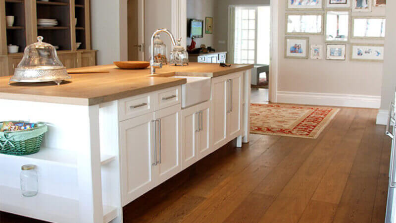 Wide plank oak wood flooring in kitchen is finished with Oil Plus 2C.
