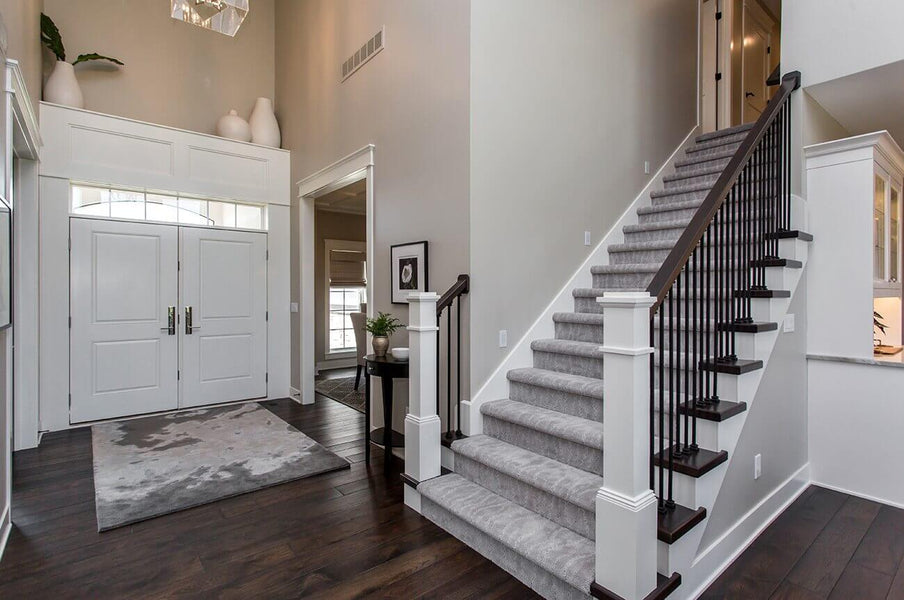Dark wood flooring in an entry with a stairway leading upstairs.
