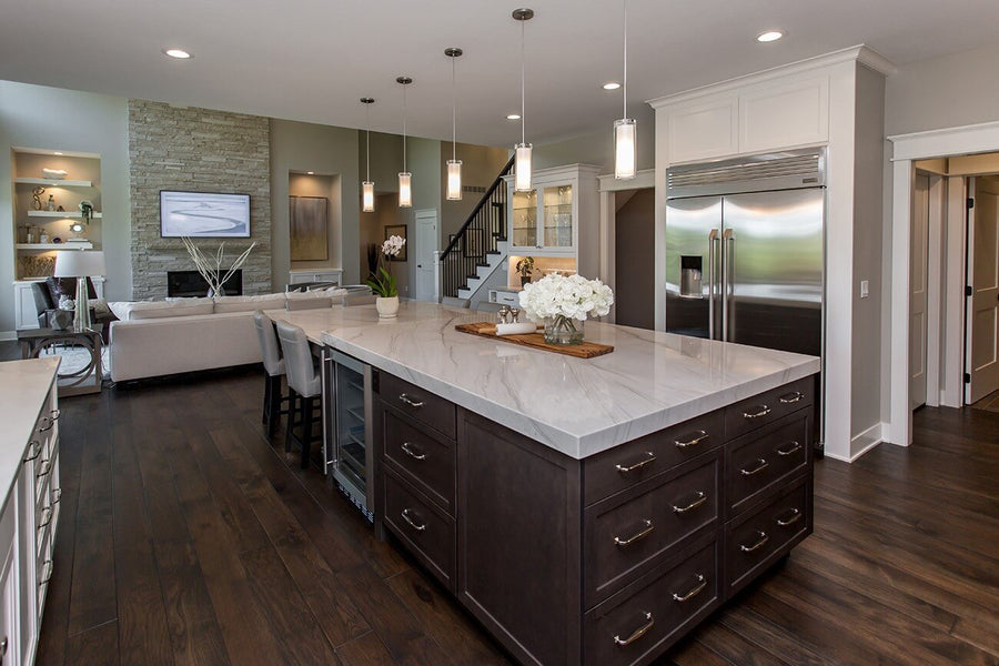 Dark wood floors in an open kitchen with light cabinetry and counters.