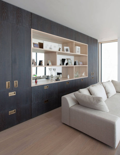 Dark build in wall cabinets with light hardwood floor.