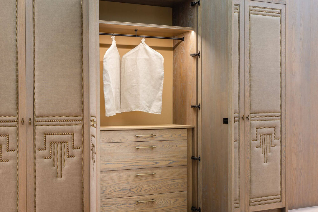 Luxurious bedroom with wood paneling and built in closets on the walls.