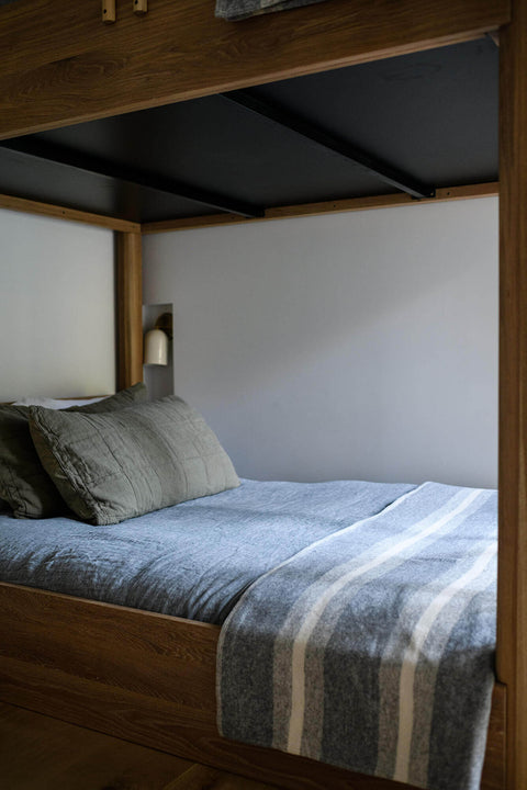 A modern made bottom bunk bed made from white oak.