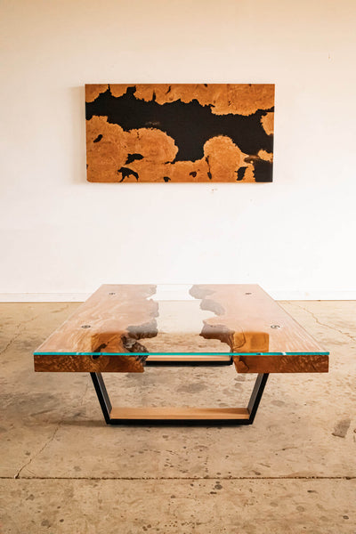 Burled maple live edge table with metal base and glass top.