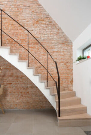 A curving stairway made out of oak wood and finished with a plant-based hardwax oil wood finish.